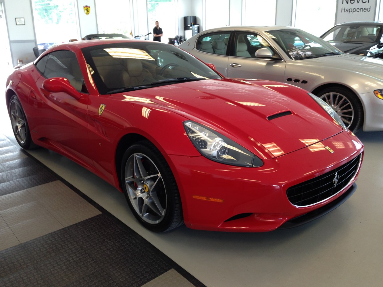 Red luxury coupe front with distinctive headlights and alloy wheels