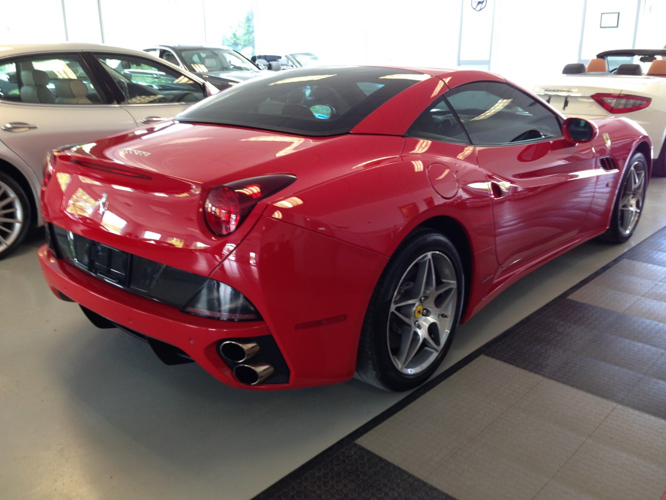 Red sporty coupe with dual exhaust and alloy wheels rear side view