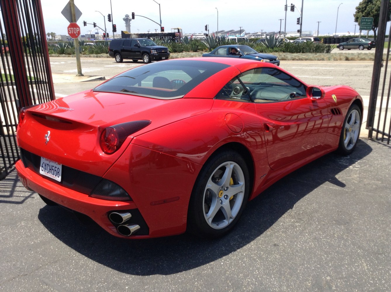 Red sports car rear side with dual exhaust and sleek roofline