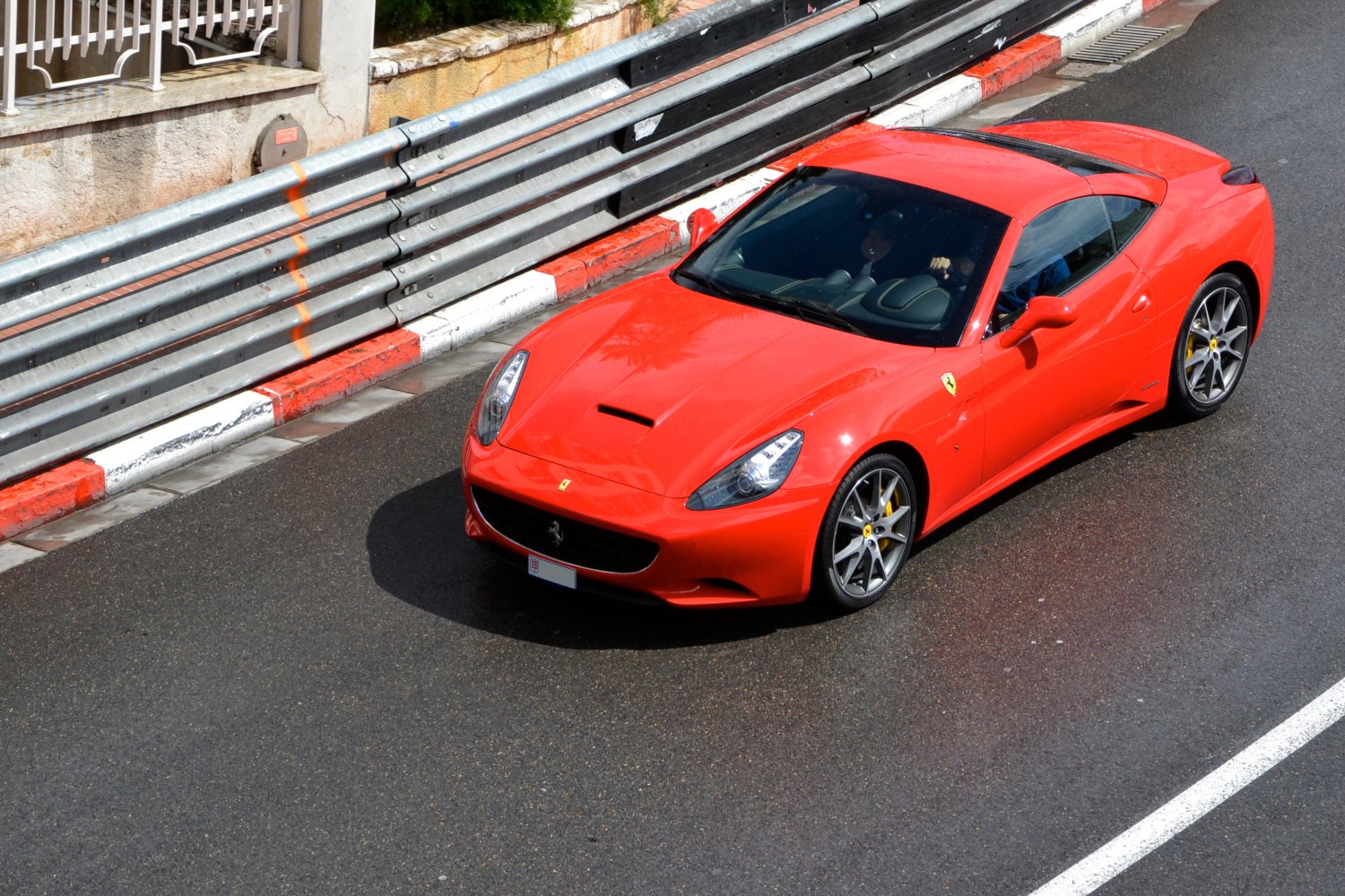 Red sports coupe with aerodynamic body and alloy wheels on wet track