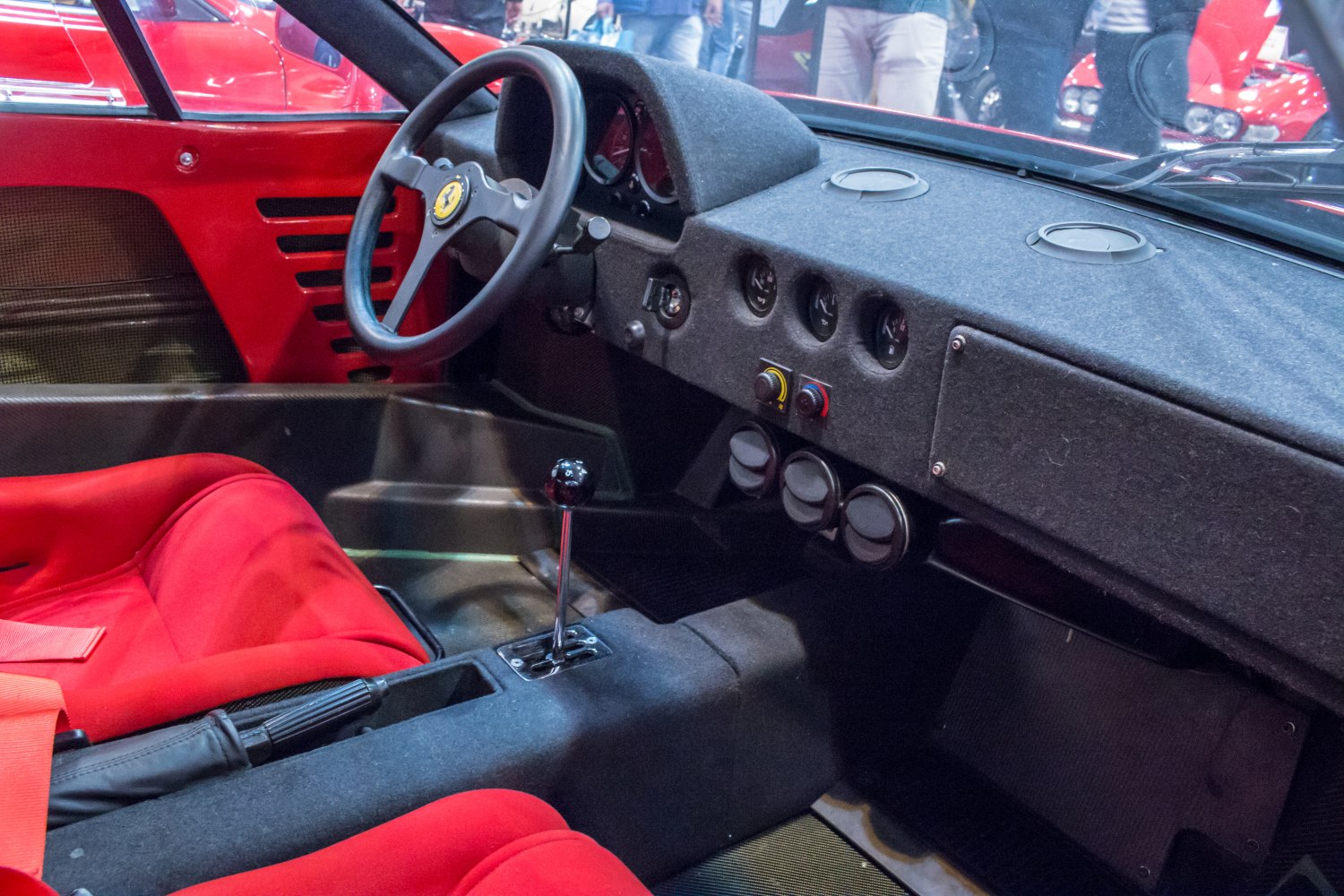 Classic Ferrari race-inspired interior with red bucket seats and minimalist dashboard