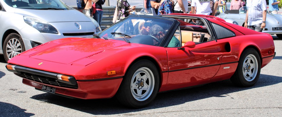 Red sports coupe with pop-up headlights and alloy wheels