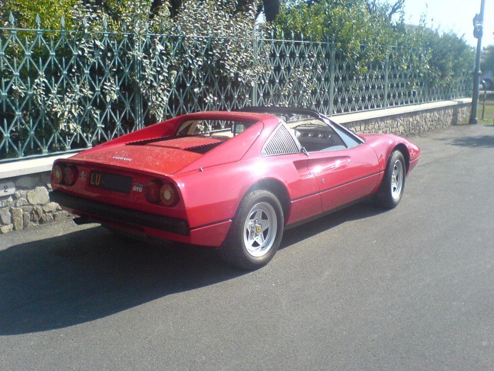 Rear view of a classic mid-engine sports car with round taillights and rear grille.
