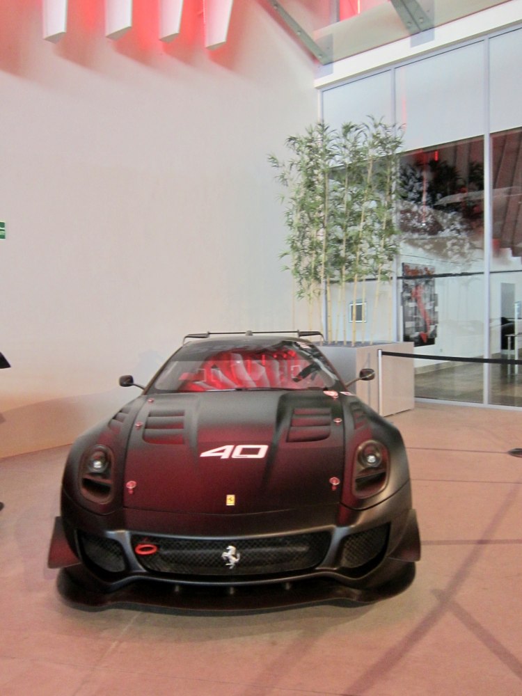 Front view of a race-prepared Ferrari with vented hood and wide aerodynamic body.
