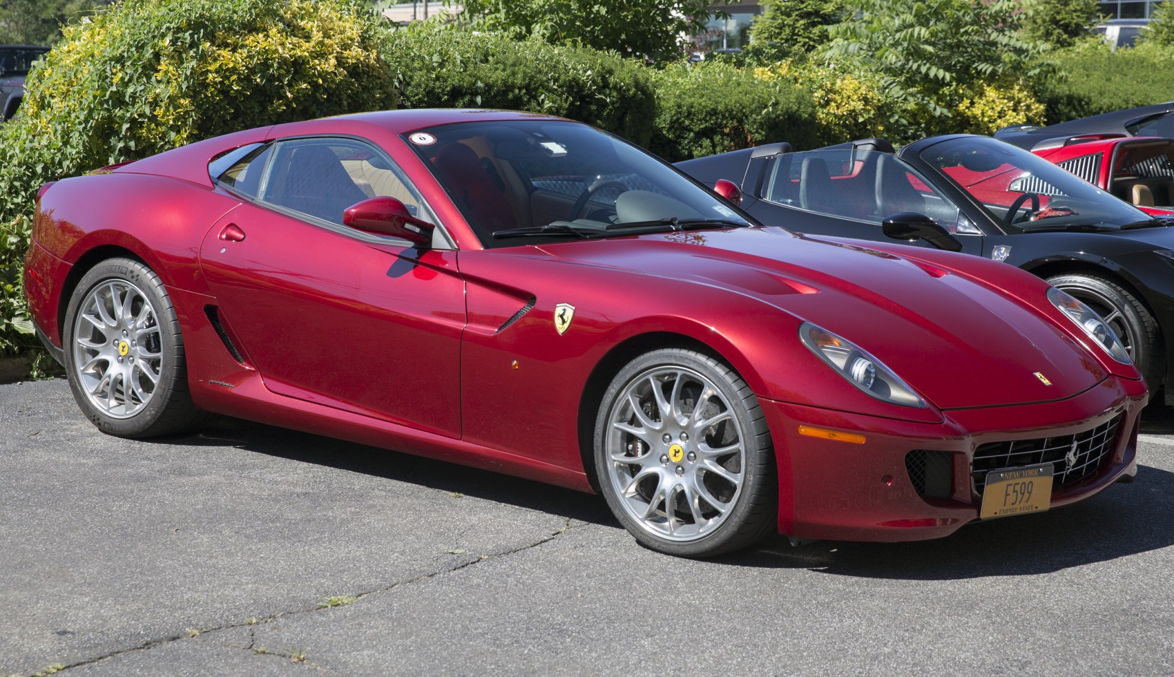 Red sports coupe with aerodynamic side vents and multi-spoke alloy wheels.