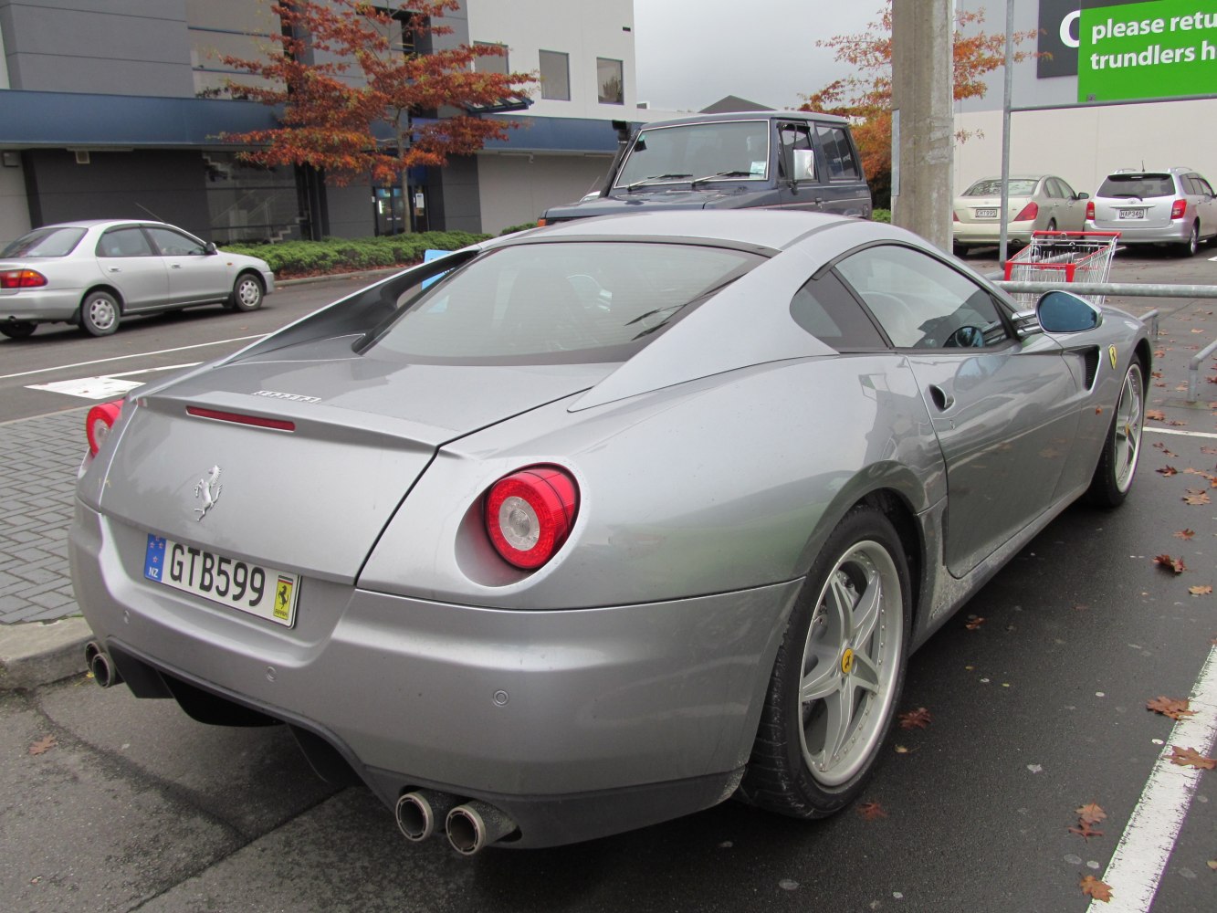 Silver sports car rear view with round taillights and dual exhaust