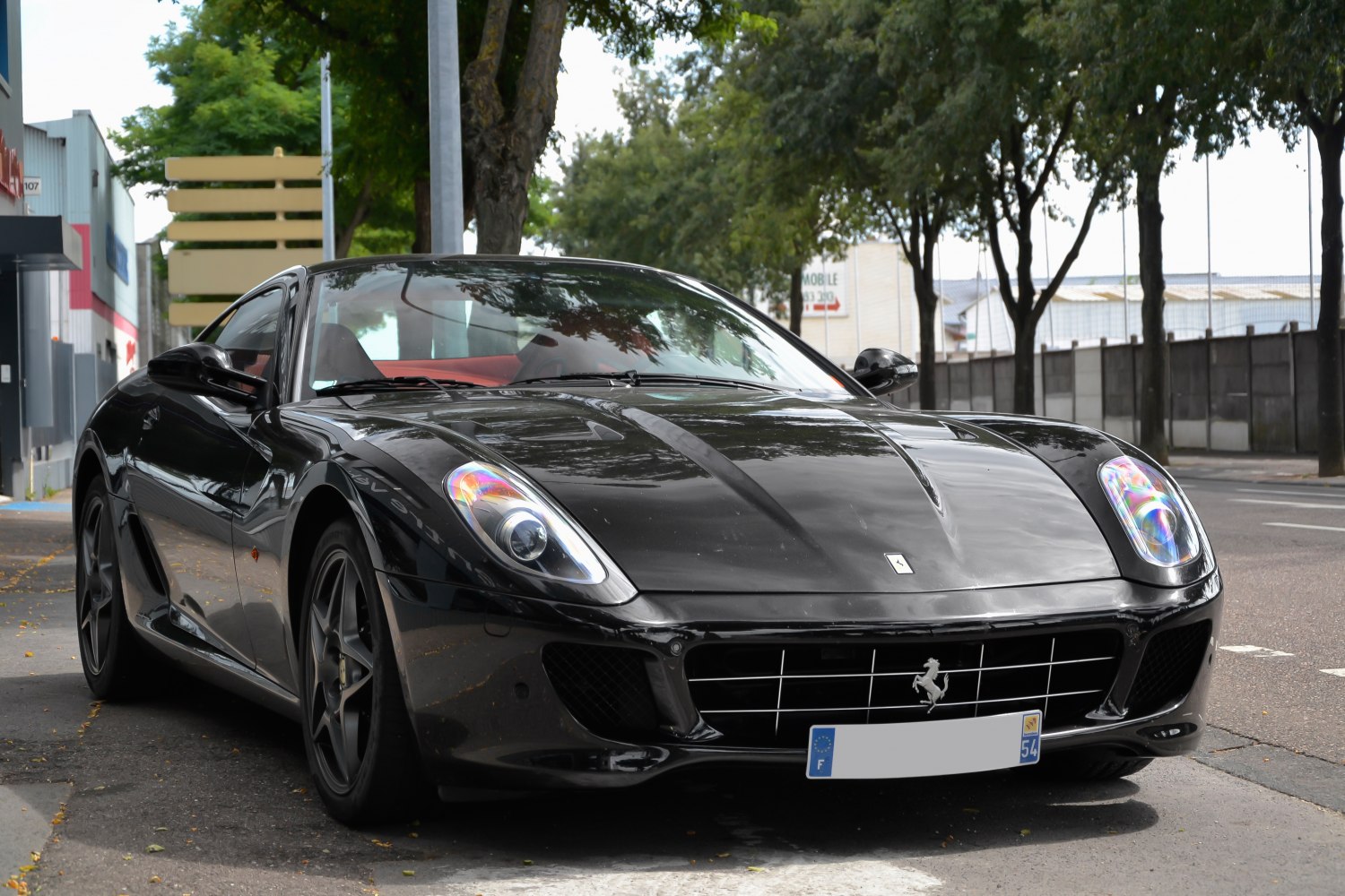 Sleek black sports car front with distinctive headlights and grille