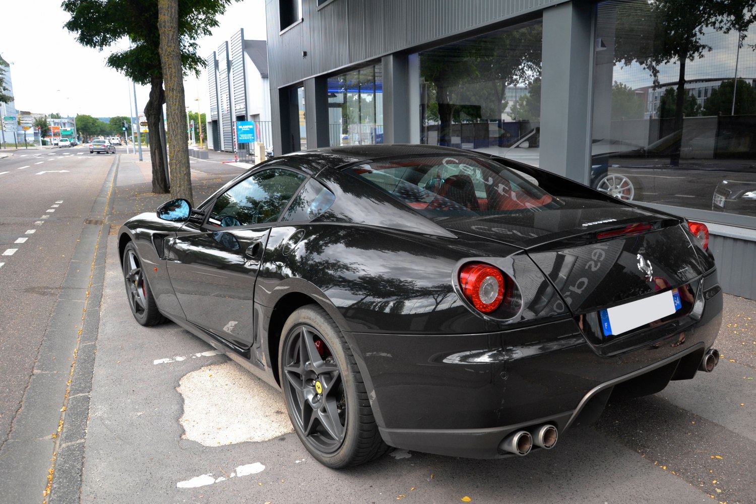 Rear side view of black Ferrari 599 GTB with taillights and quad exhausts