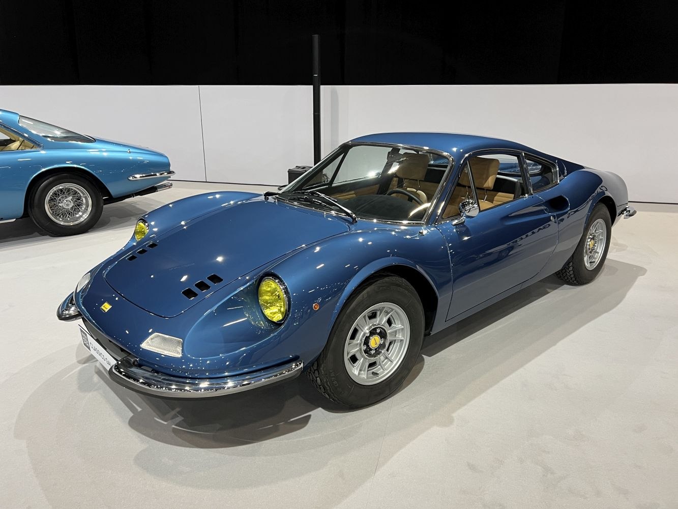 Blue sports coupe with yellow headlights and prominent hood air vents