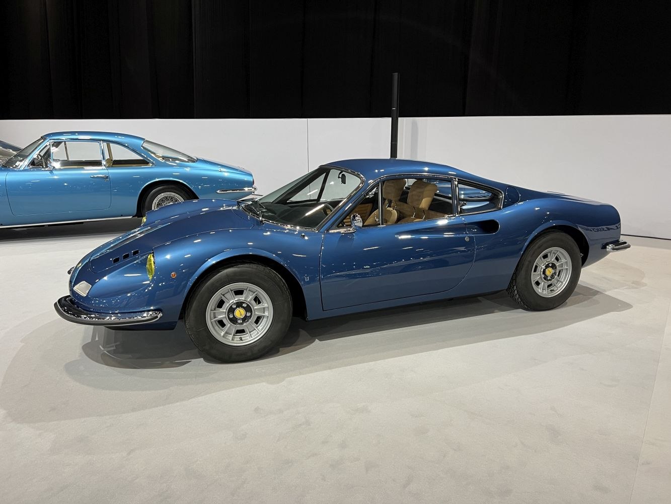 Blue mid-engine coupe with rounded headlights and sporty vintage design