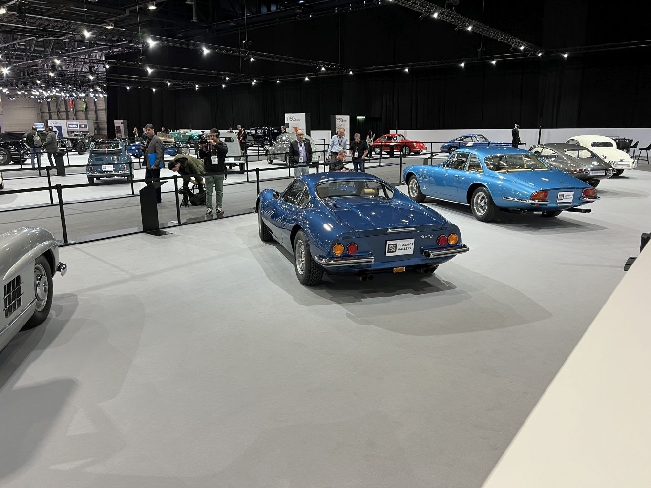 Rear view of a sleek blue classic sports coupe with dual round tail lights