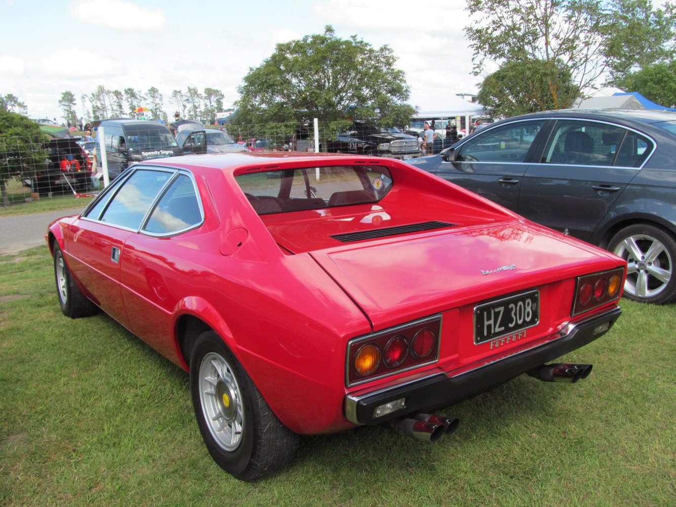Rear view of mid-engine vintage sports coupe with angular design and dual exhausts