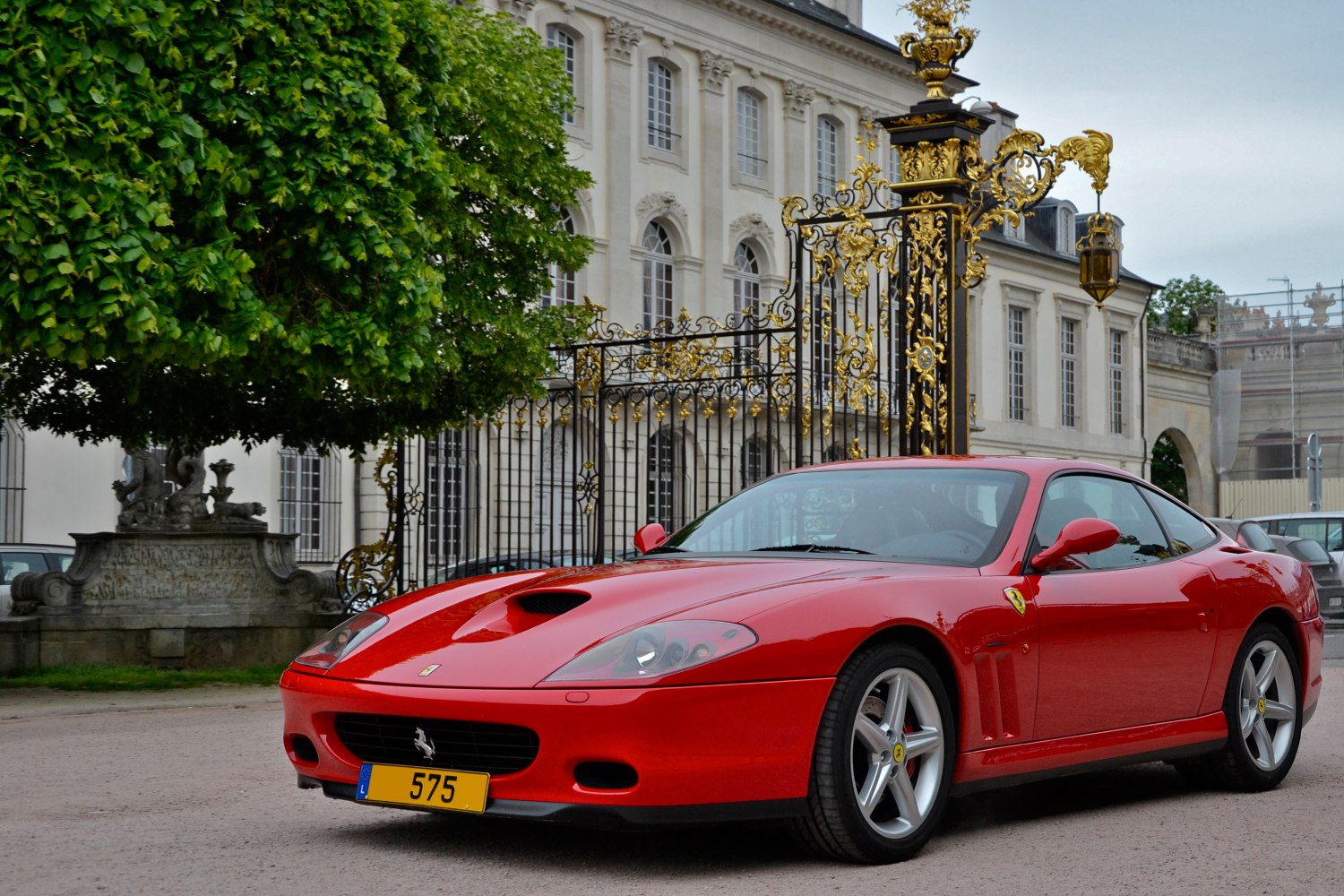 Red sports coupe front side view with hood scoop and alloy wheels