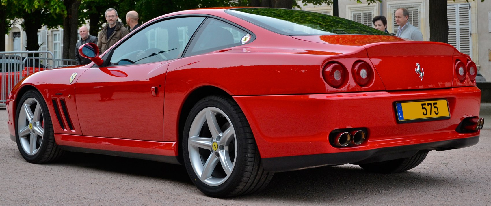 Red sports coupe rear and side profile with round tail lights and dual exhaust pipes