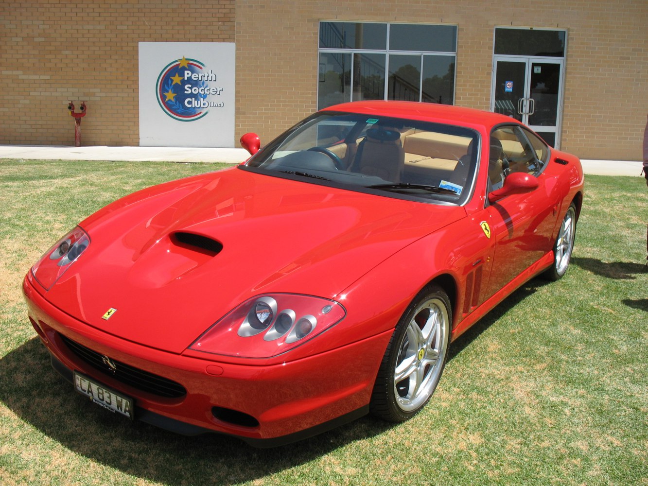 Front view of red sports car with hood scoop and alloy wheels