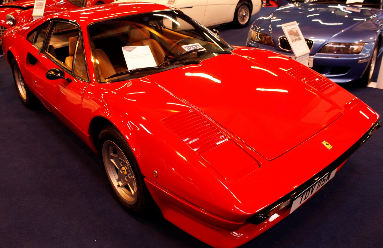 Red classic coupe with pop-up headlights and vented hood