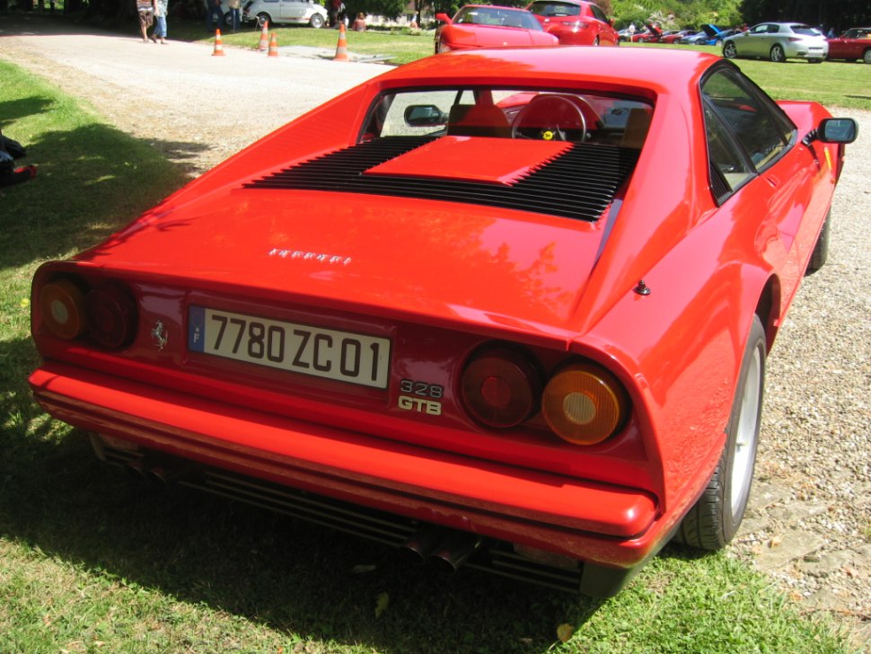 Red sports coupe rear, quad round taillights, rear engine vents.