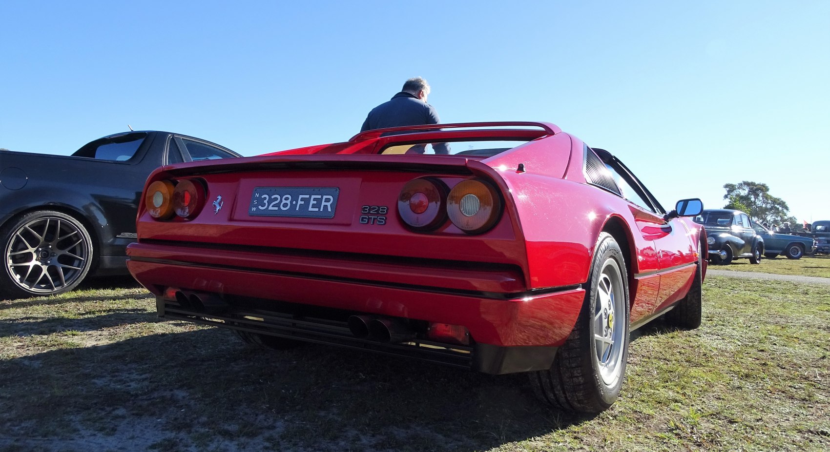 Rear view of a red sports car with distinct taillights and dual exhaust.