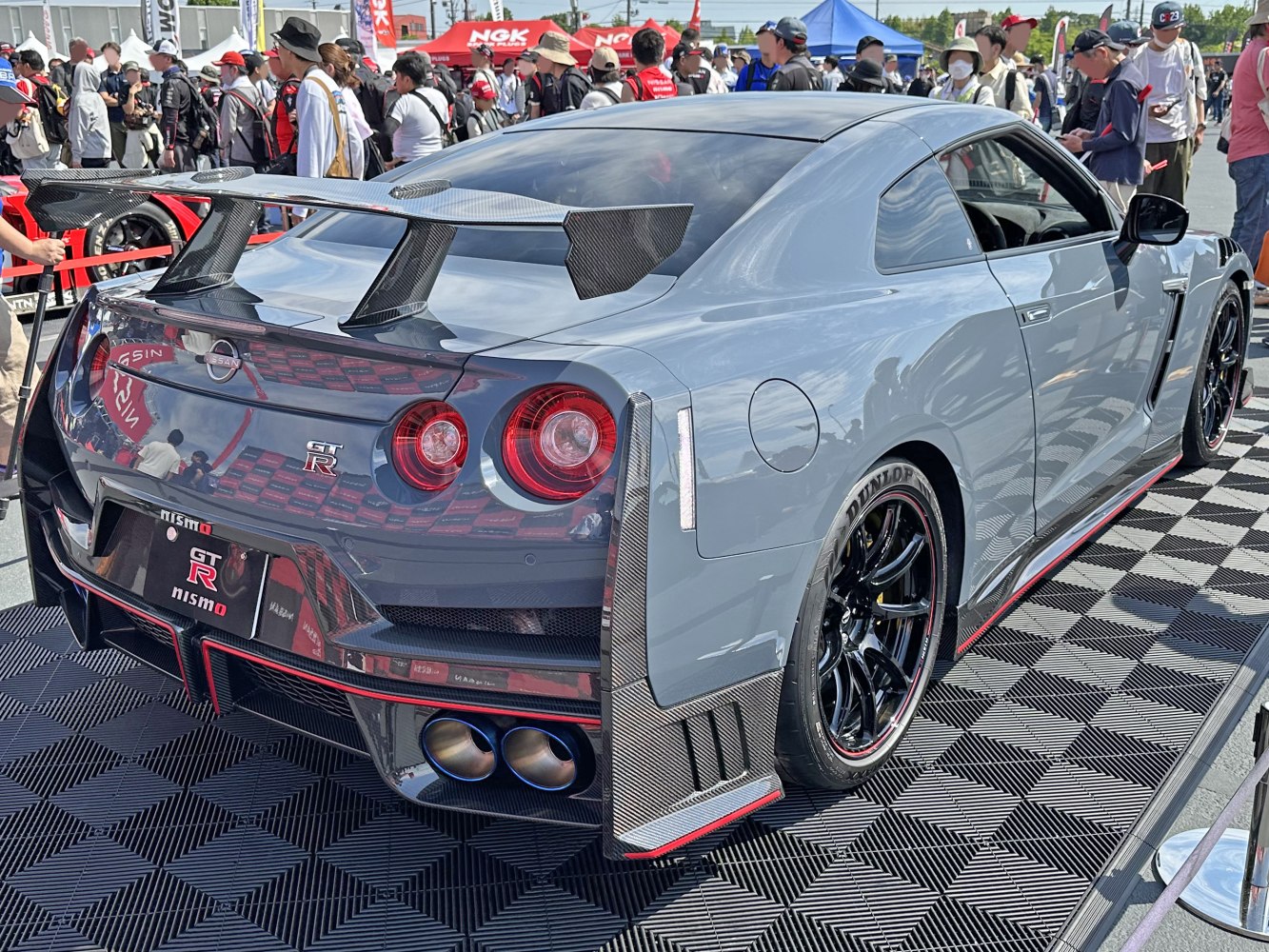 Rear view of sports car with carbon fiber wing and quad exhaust pipes