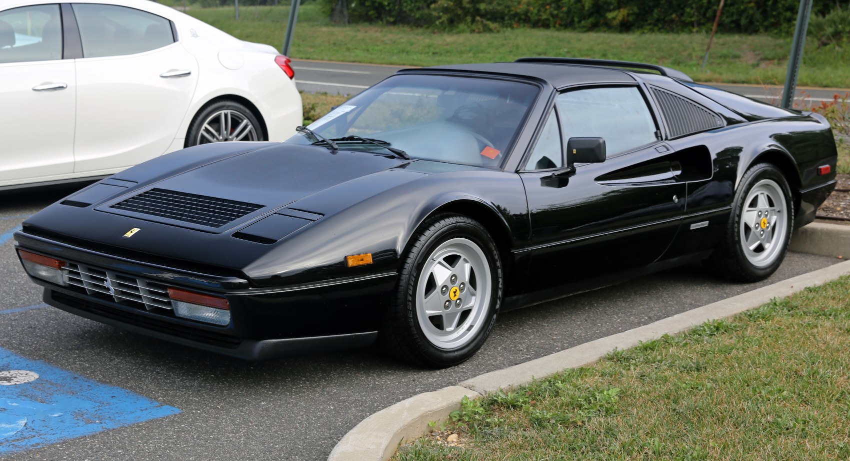 Black sports car with pop-up headlights and five-spoke alloy wheels
