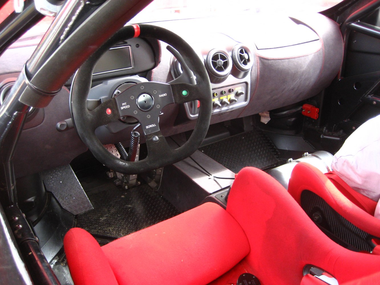 Race car interior with custom steering wheel and red bucket seats