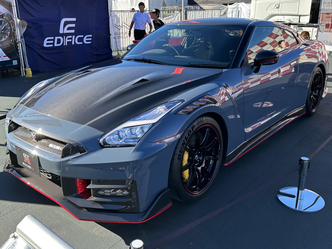Carbon fiber hood, aerodynamic front, LED headlights, black wheels with red accents