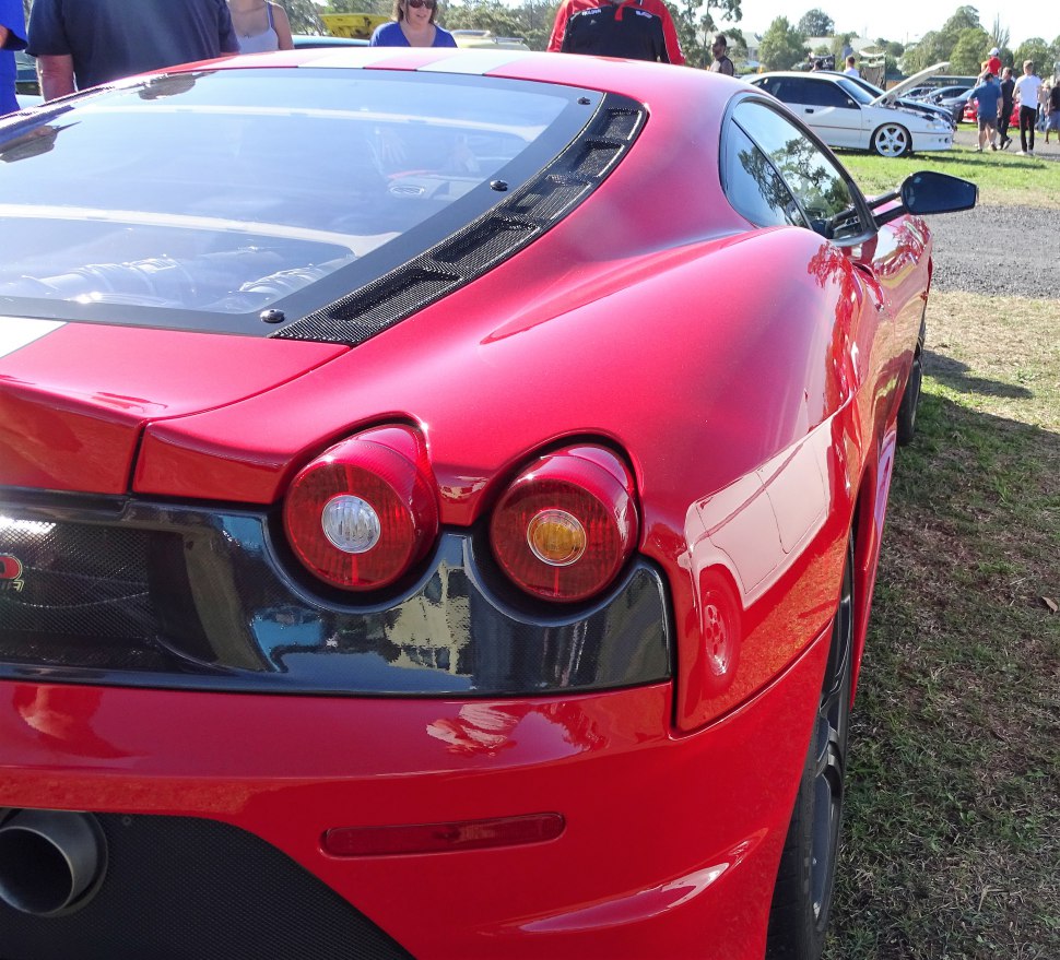 Close-up on dual round taillights and glass engine cover at rear.