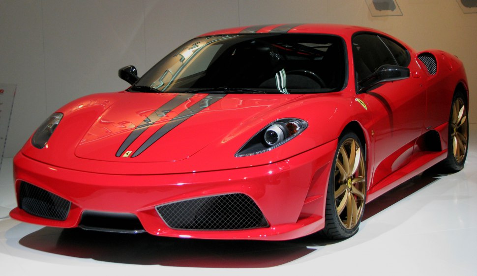 Front view of sports car with racing stripes and gold alloy wheels