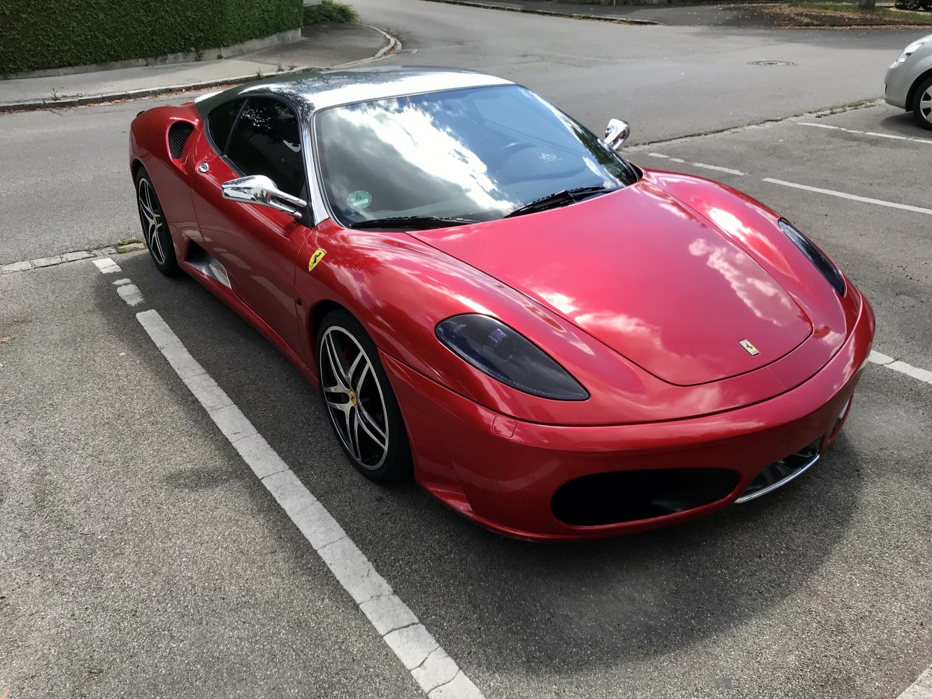 Sleek front three-quarter view of a red sports coupe with aerodynamic design and distinctive alloy wheels