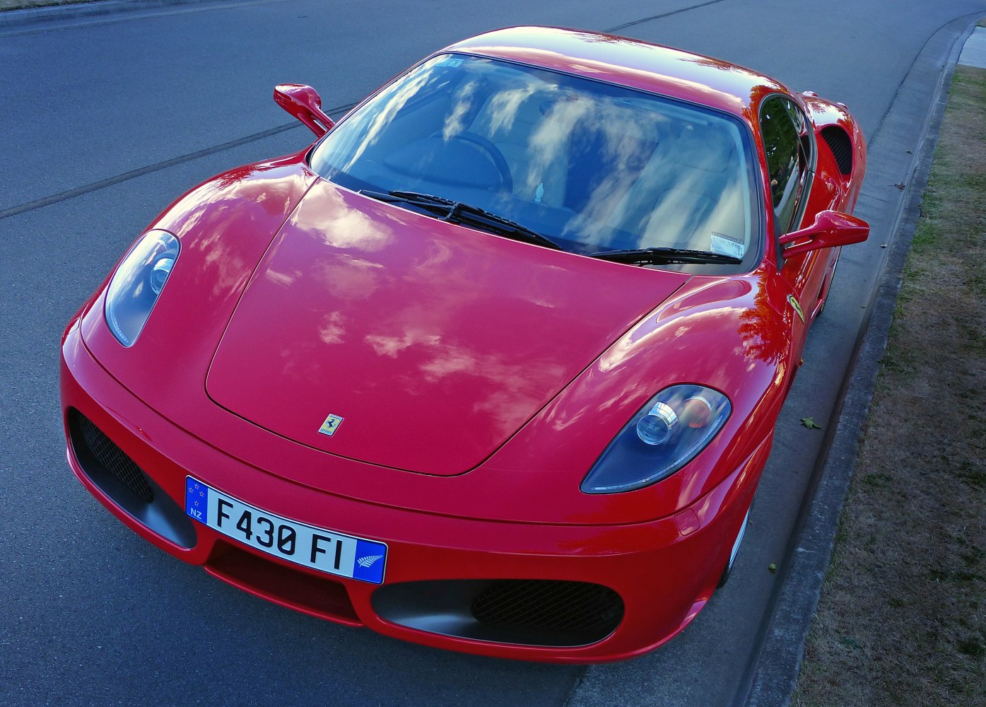 High-angle front view of red sports car hood and headlights