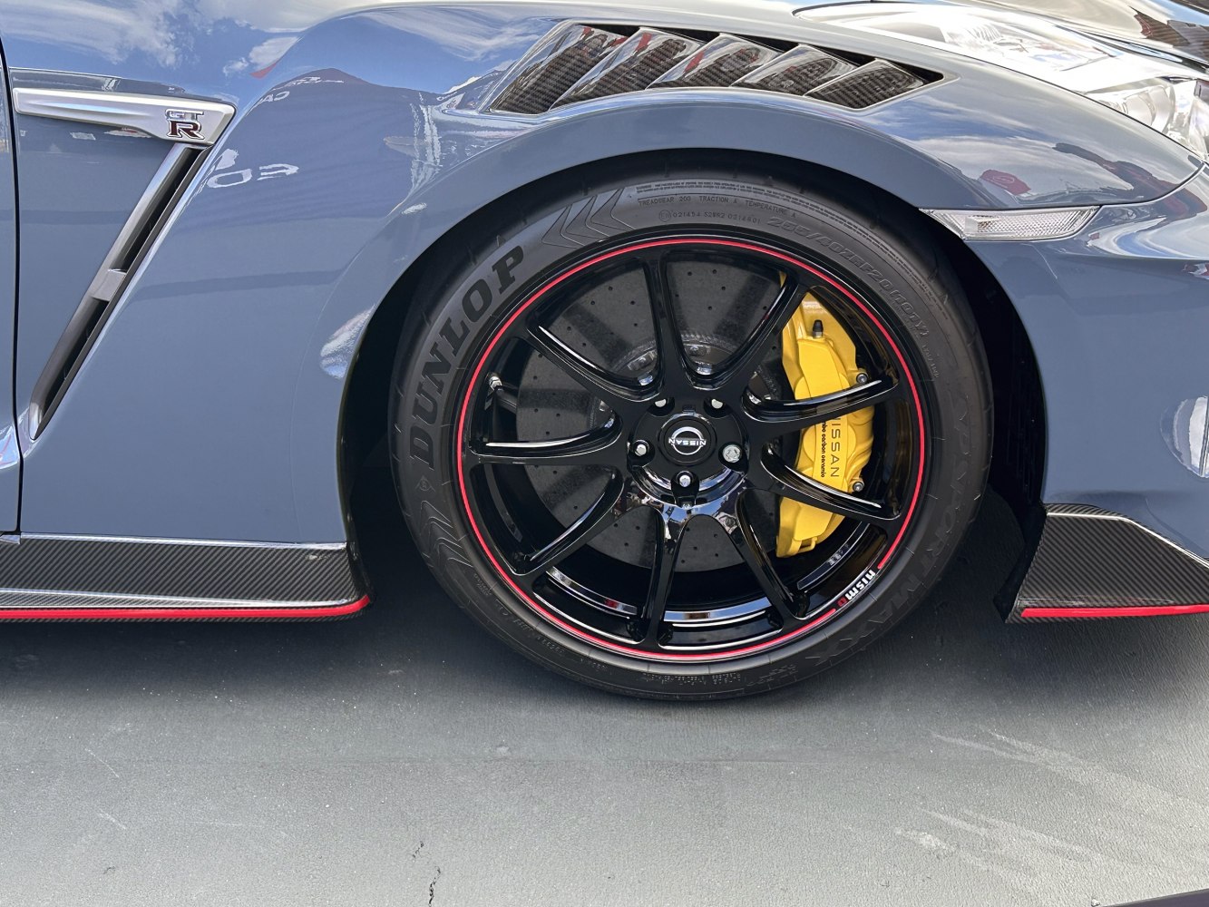Black multi-spoke alloy wheel with yellow brake caliper and red rim accent