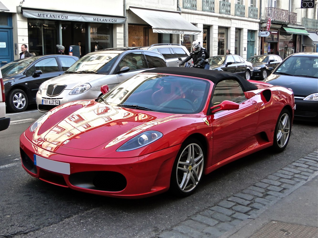 Red convertible sports car with black soft top and sleek aerodynamic design