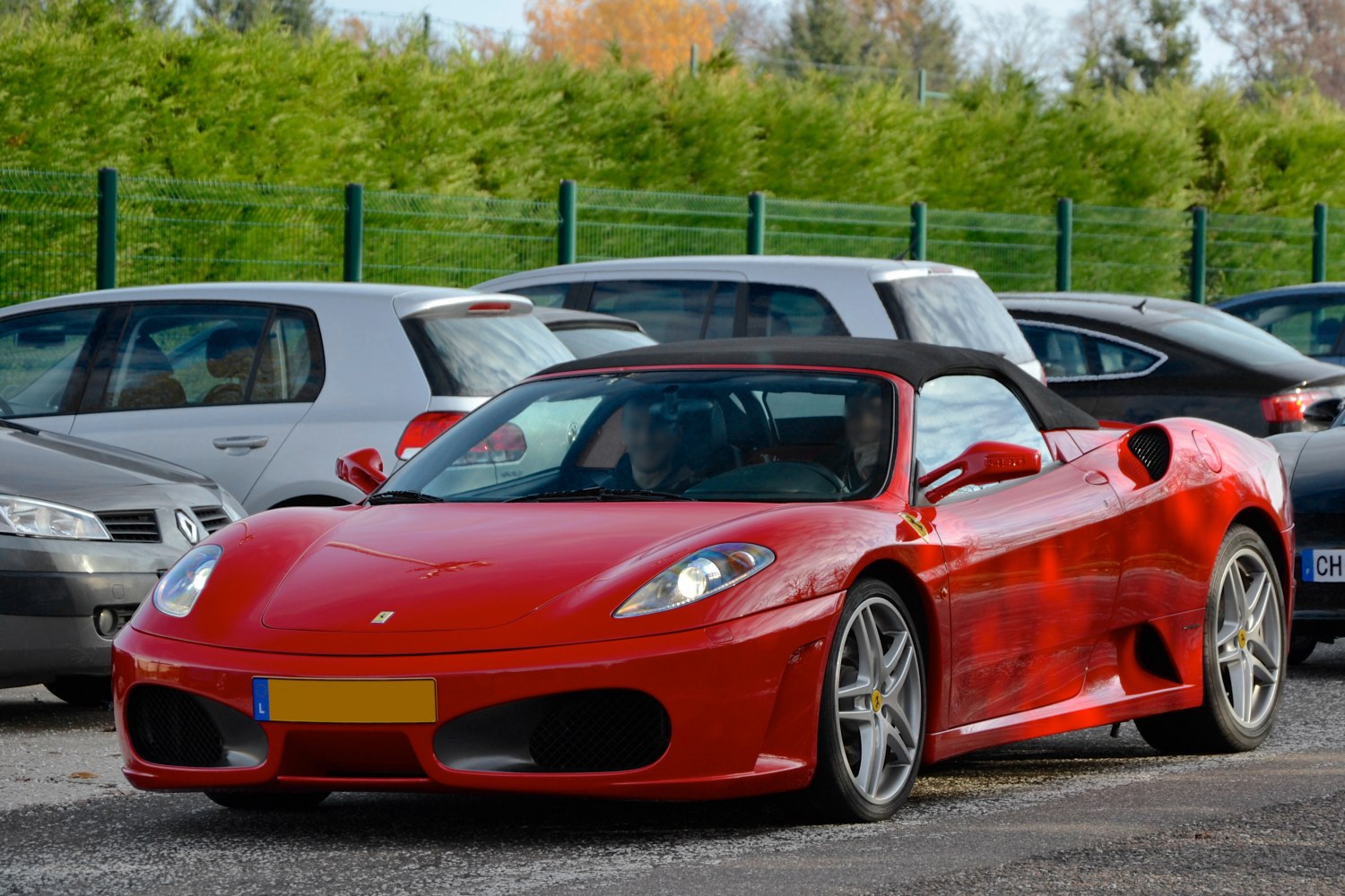 Red convertible sports car with soft fabric roof and aerodynamic vents
