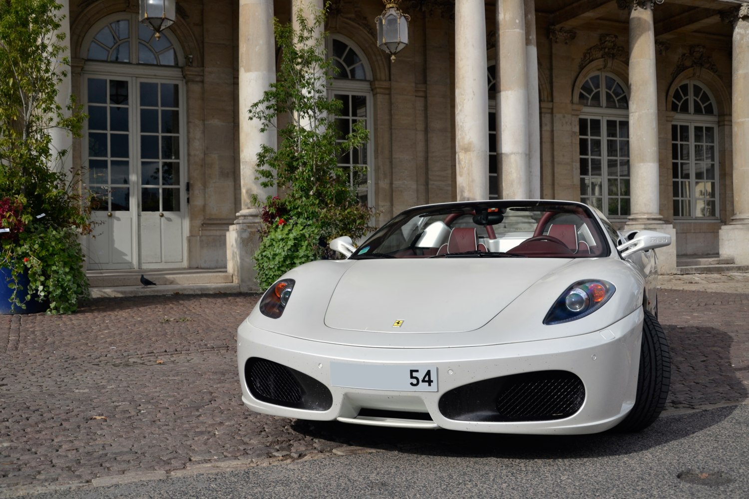 Front view of white convertible sports car with distinctive headlights and aerodynamic bumper