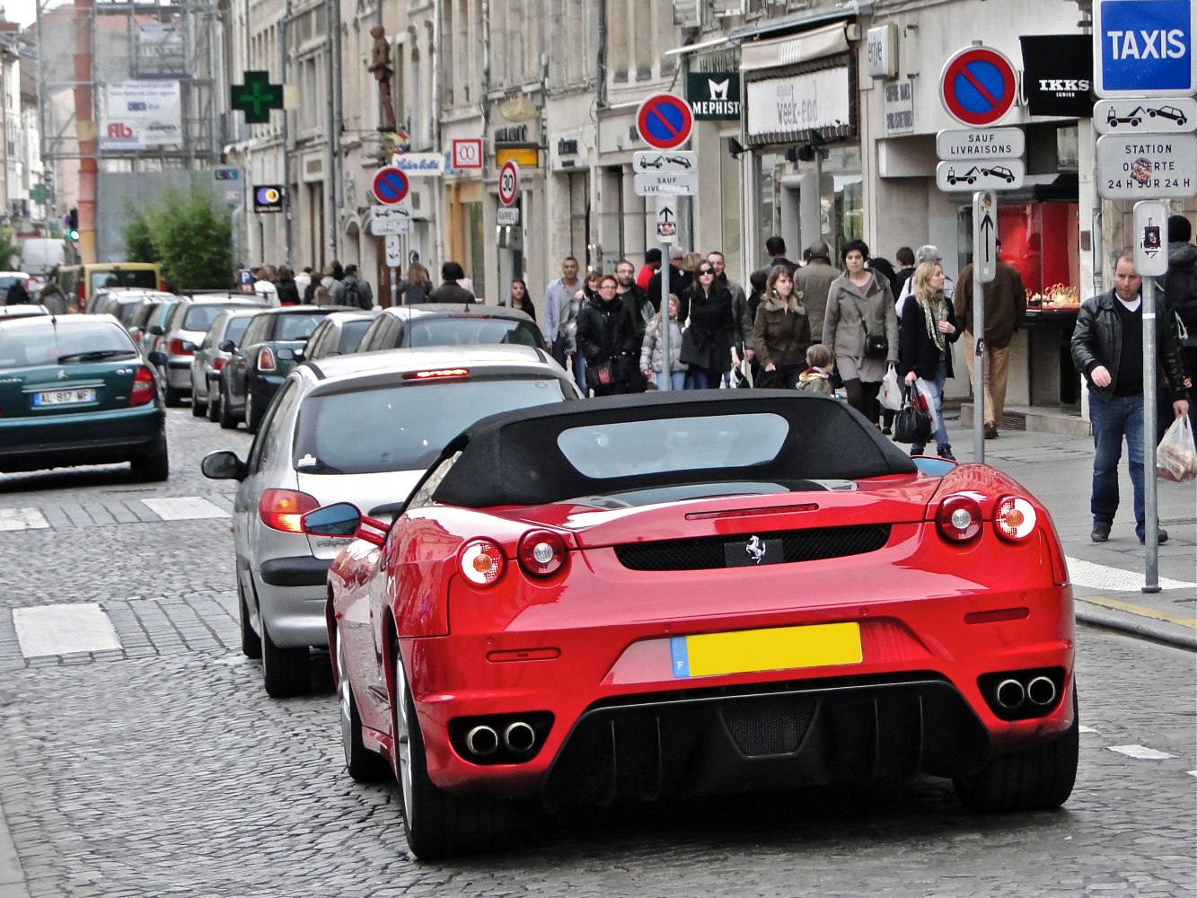 Rear view of red convertible sports car with quad exhaust and distinctive taillights