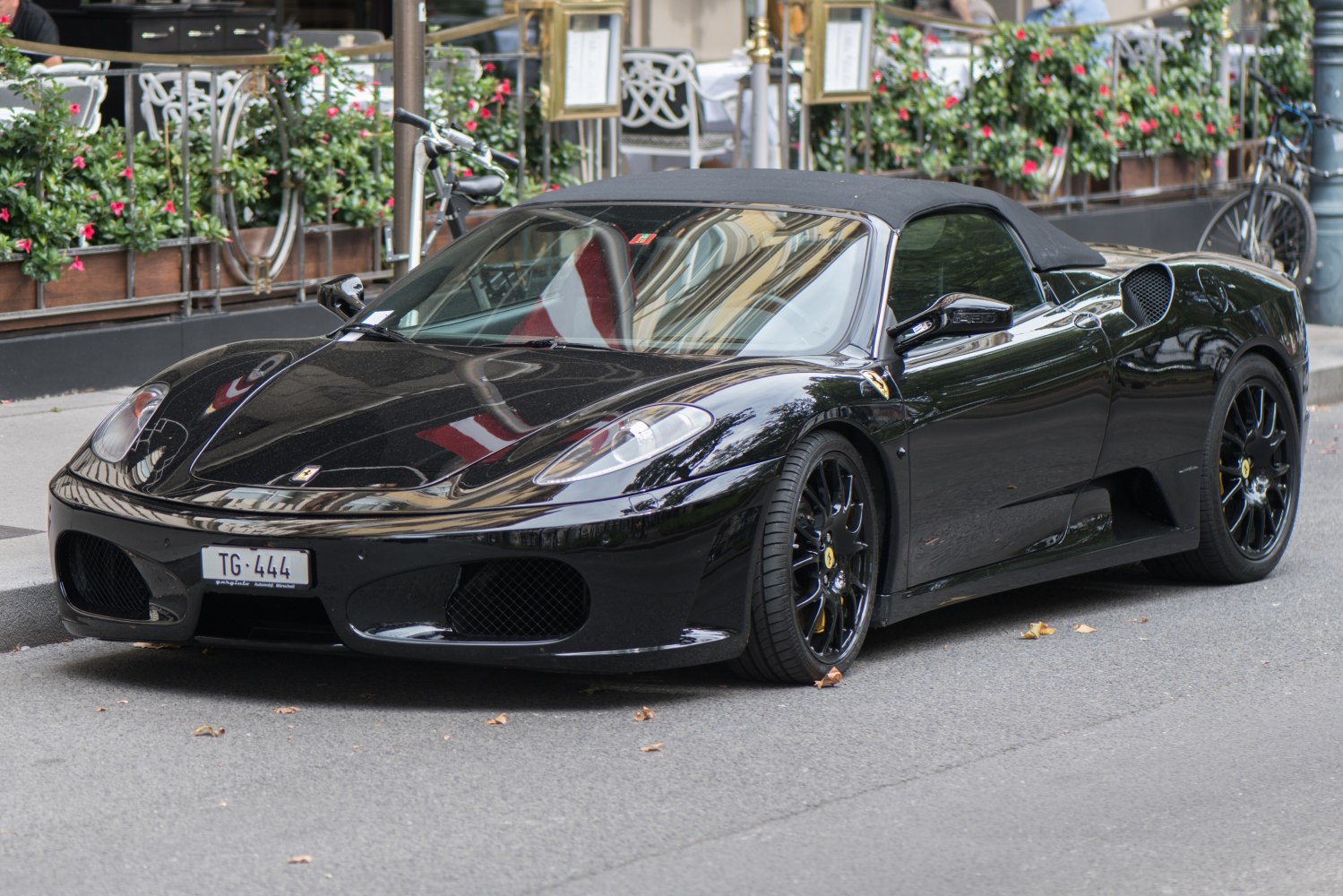Black convertible sports car with soft-top roof and sleek aerodynamic body.