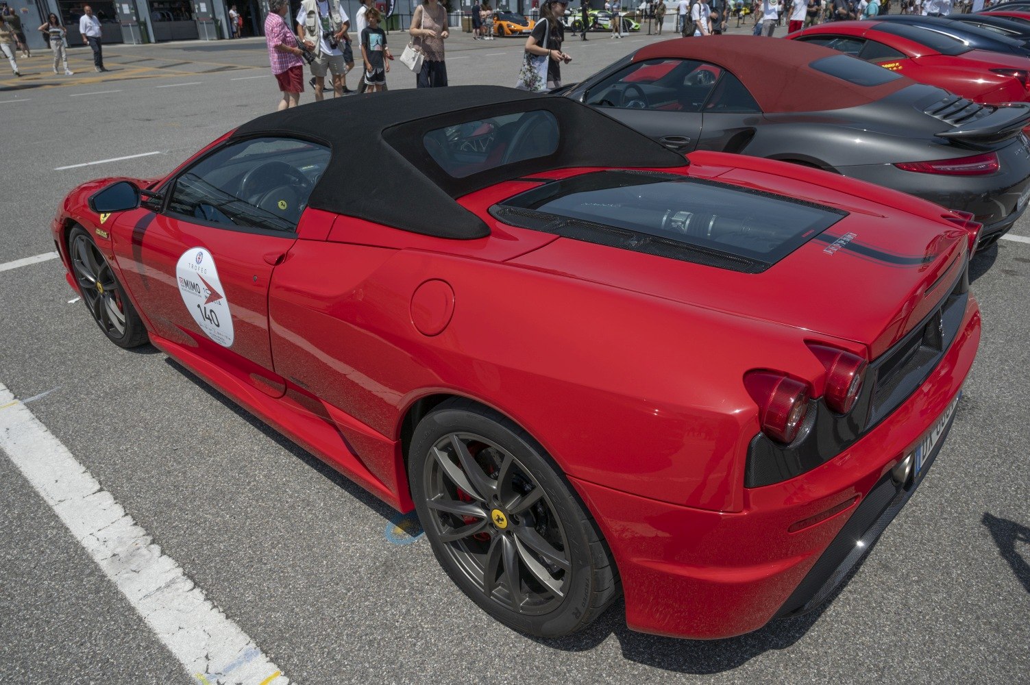 Red convertible with black soft top and rear engine cover