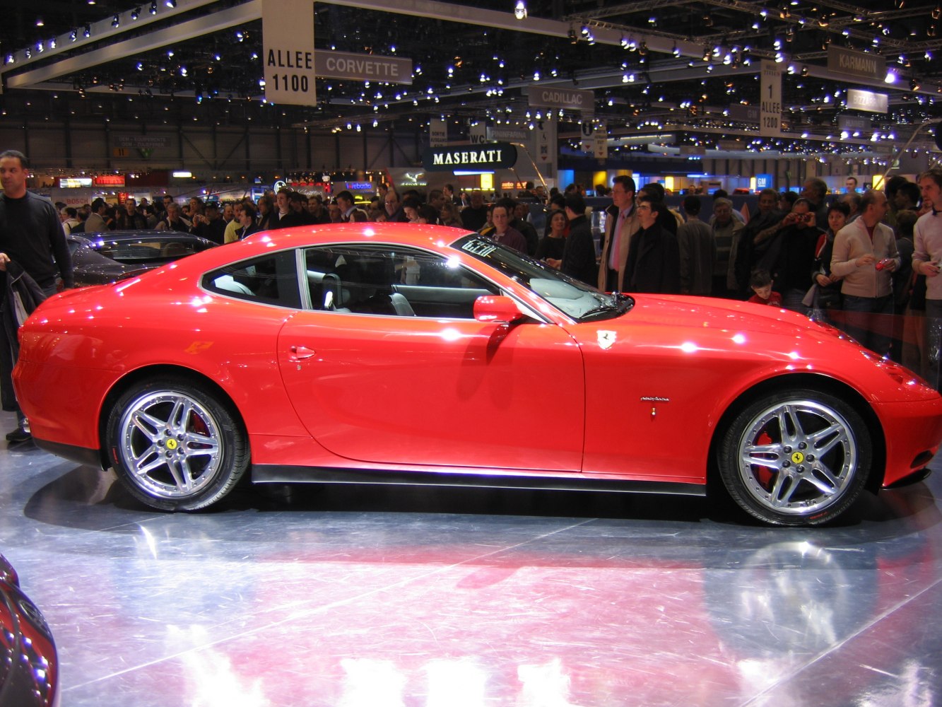 Red luxury coupe with sleek side profile and distinctive alloy wheels