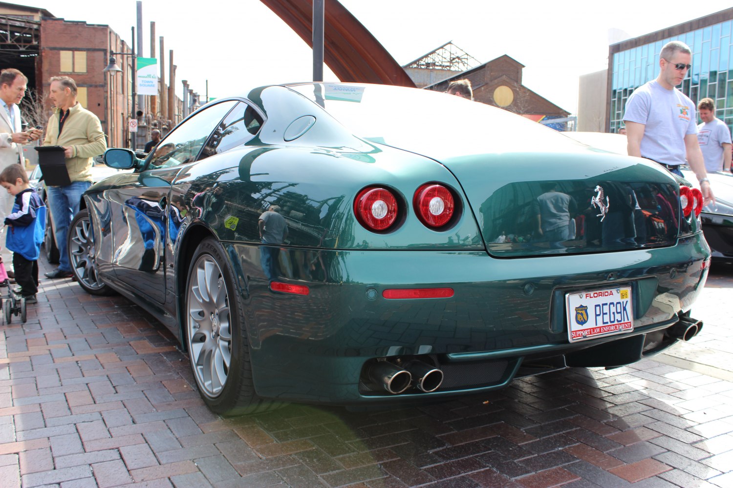 Green luxury coupe rear with round taillights and quad exhausts