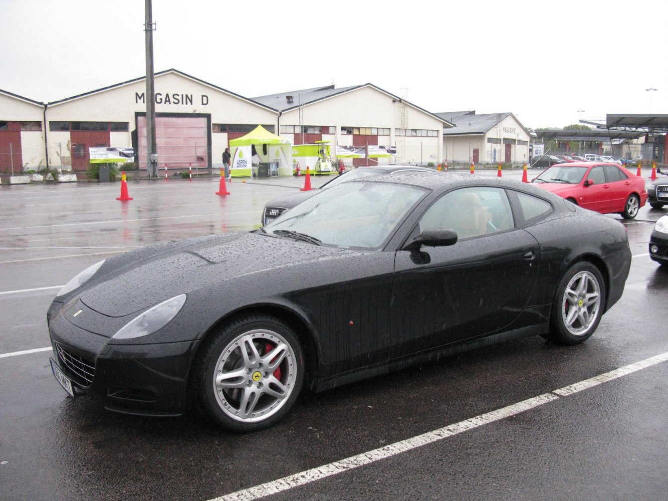 Front side view of sleek coupe with alloy wheels in rainy weather