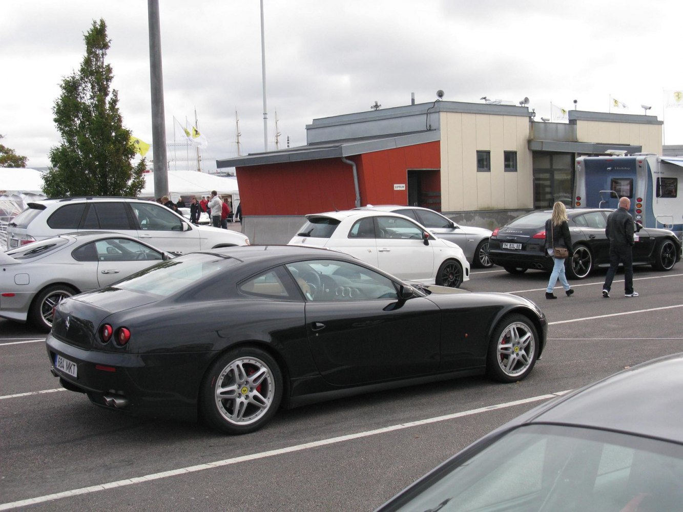 Sleek black luxury coupe with round rear lights and sporty alloy wheels.
