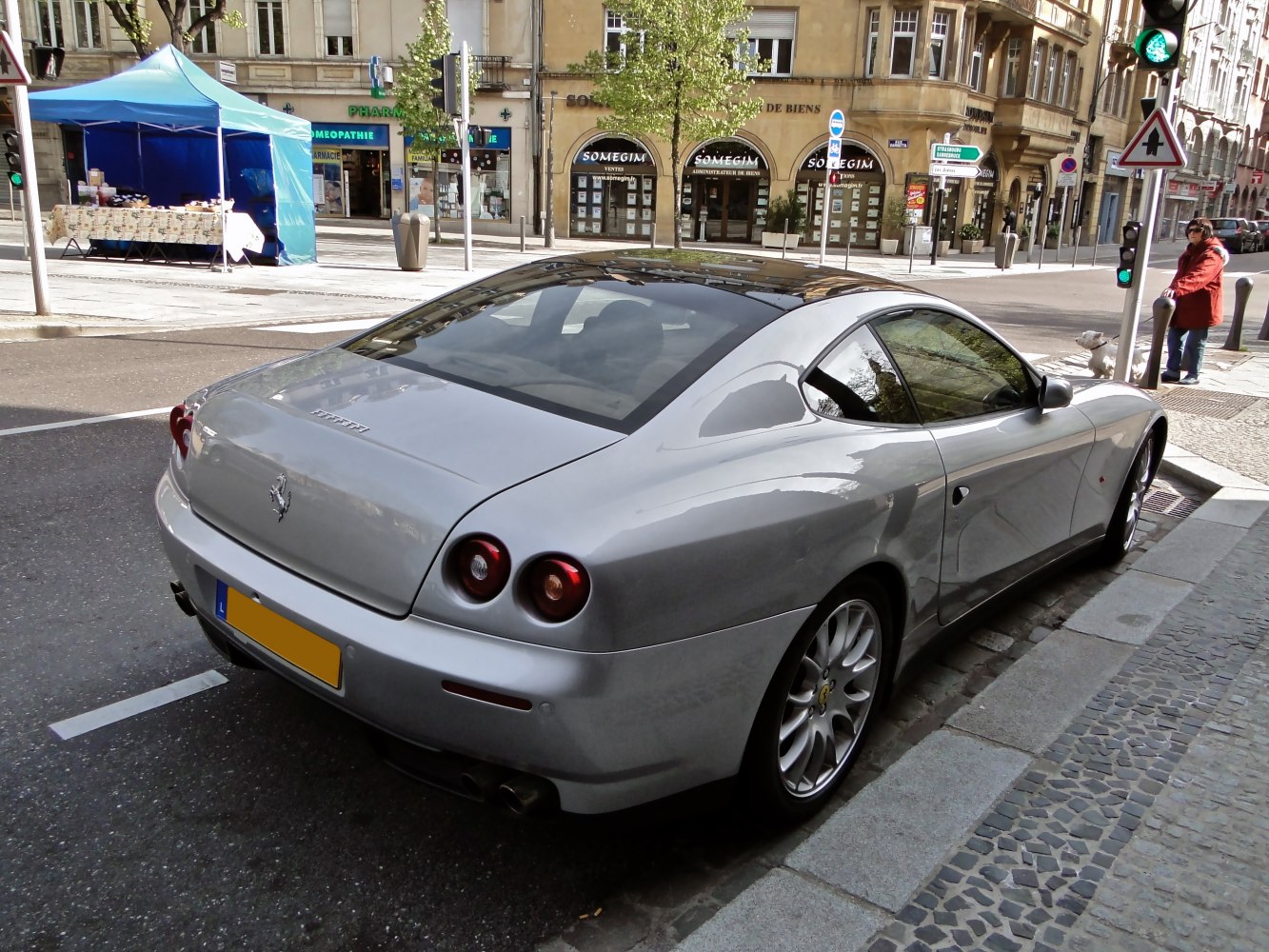 Rear view of silver coupe with round tail lights and sleek design