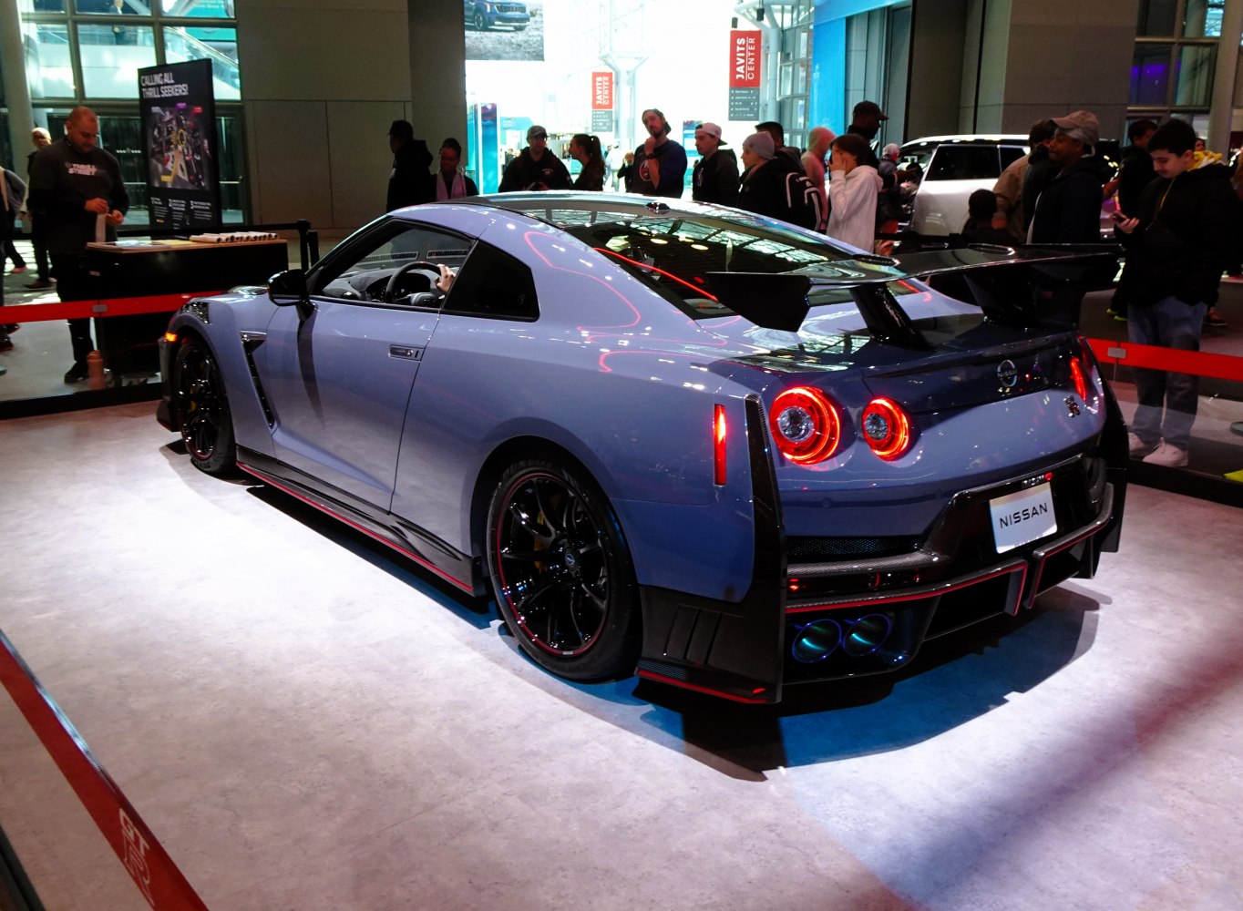 Rear view with wide wing and quad exhaust of a sports coupe