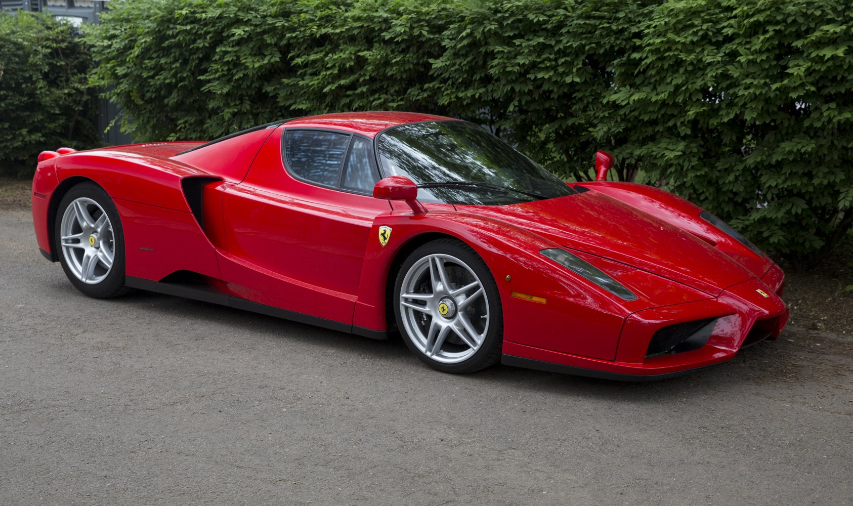 Red mid-engine sports coupe with aerodynamic body and silver alloy wheels