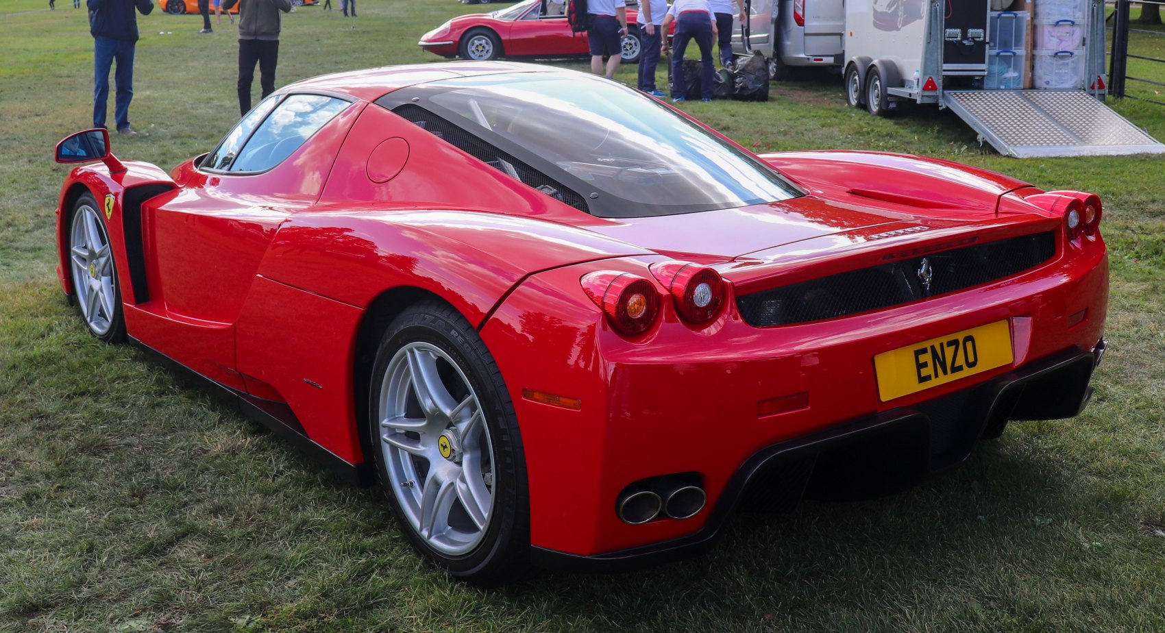 Rear view with round tail lights and dual exhausts of a red high-performance sports car.