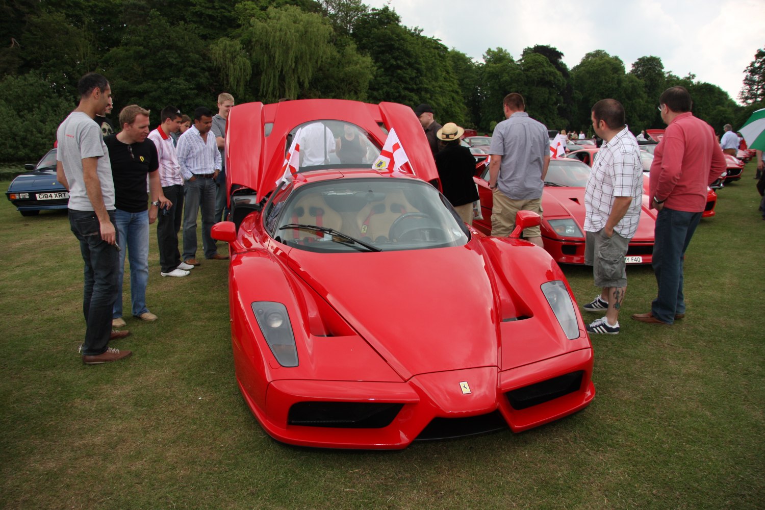 Red sports car with open rear engine hood and visible interior