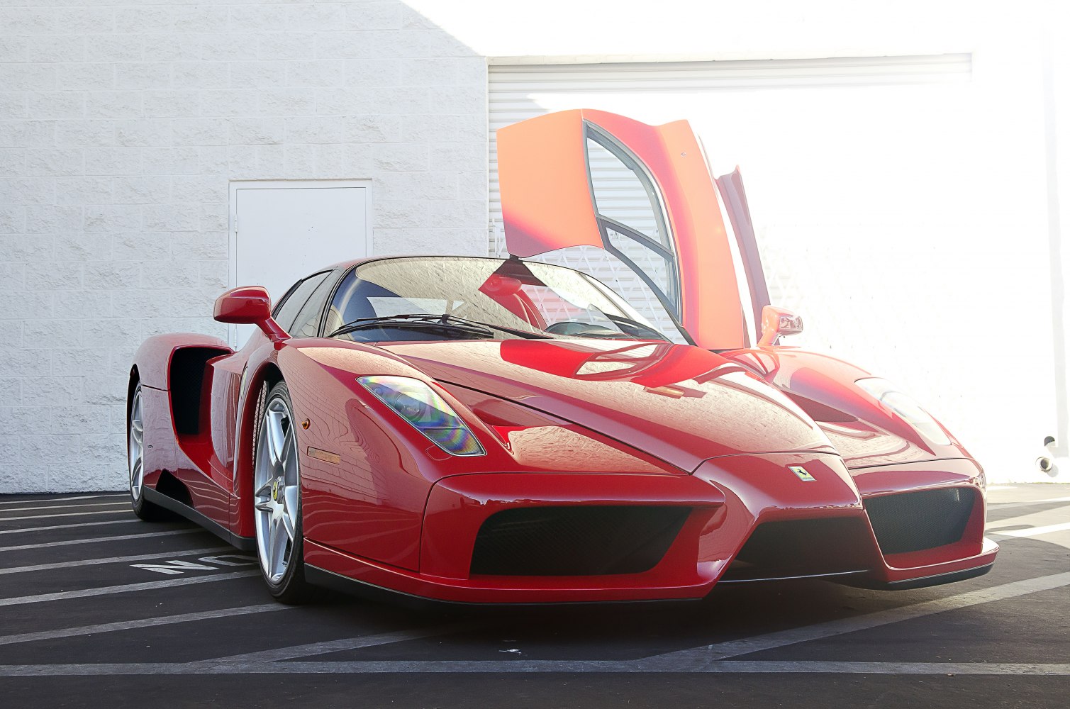 Front view of red Ferrari Enzo with one scissor door open