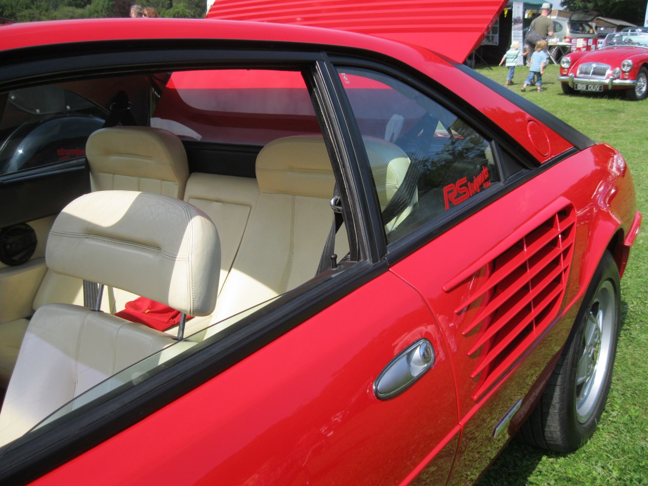 Cream leather seats and distinctive side air vents on red sports car