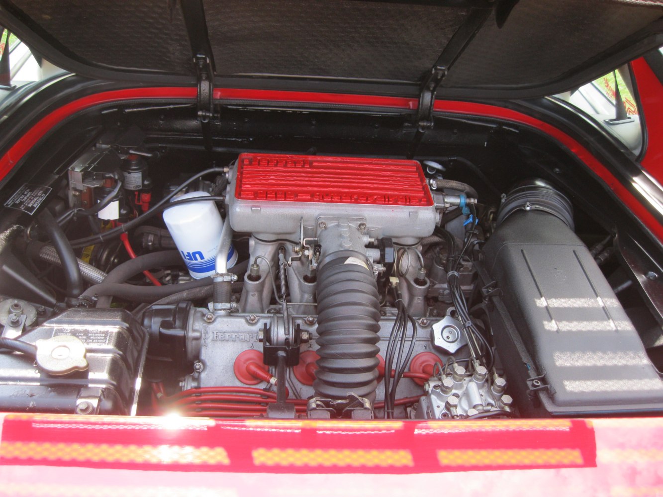 Red valve cover and air intake hose in engine compartment