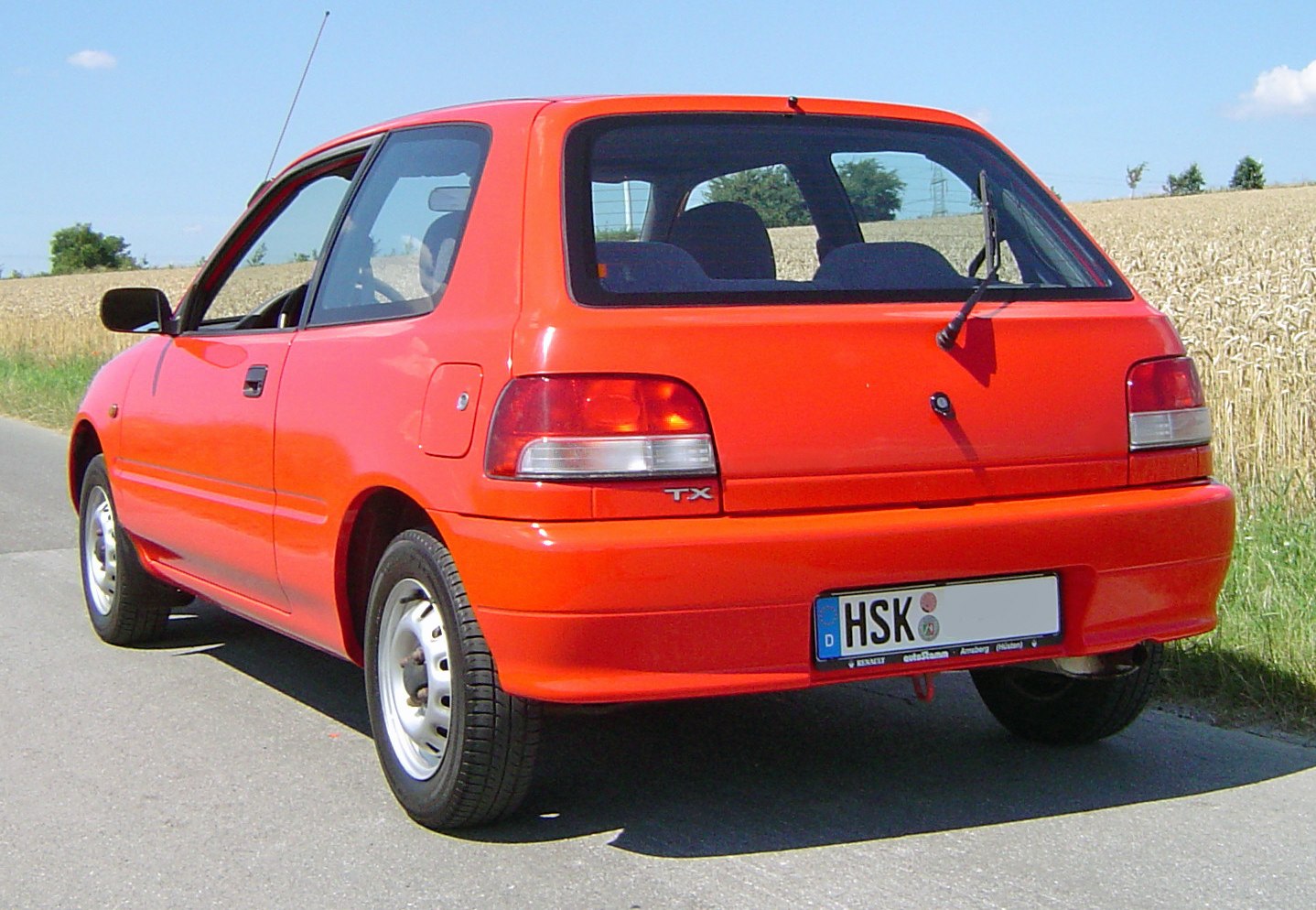 Rear view of a compact hatchback with tail lights and rear wiper
